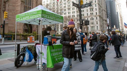 Noel Picinich picks up a COVID-19 test to administer to herself at a PCR and Rapid Antigen COVID-19 coronavirus test pop up on Wall Street in the Financial District in New York.