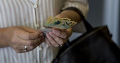 Woman holding Australian cash.