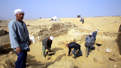 Egyptian excavation workers labor outside the tomb of an Old Kingdom priestess. (AAP)