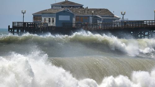 Big waves crash ashore and into the pier at Seal Beach, California. (Getty)
