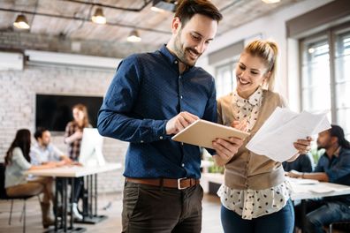 Male and female colleagues talking. Colleagues working together. Workplace. Coworkers talking. Male and female coworkers.