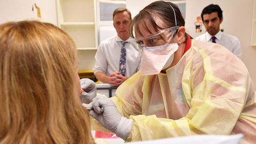 A GP performs a mock coronavirus examination on a patient inside the fever clinic at the Prince Charles Hospital in Brisbane.