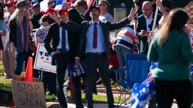 Supporters of President Donald Trump stand outside Trump National Golf Club, Sunday, Nov. 8, 2020, in Sterling, Va. (AP Photo/Evan Vucci)