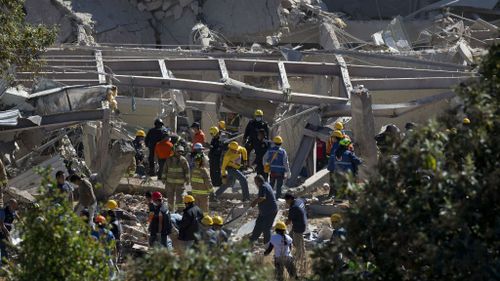 Rescue workers sift through the rubble at the Mexico City hospital. (AAP)