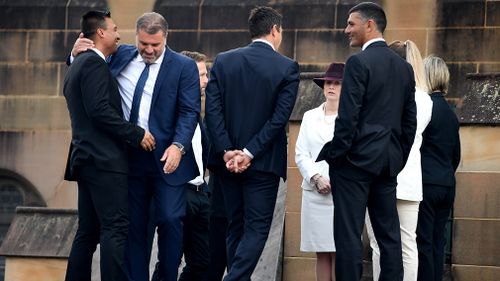 Mourners, including Socceroos coach Ange Postecoglou, gather outside the church. (AAP)