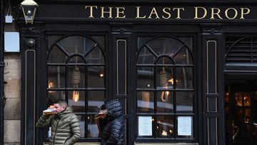 Members of the public enjoy a drink at the Last Drop pub in the Grassmarket prior to last orders at 6pm on October 9, 2020 in Edinburgh, Scotland. 