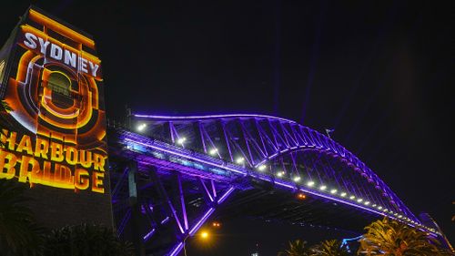 The Sydney Harbour Bridge is illuminated in " Royal Purple" to mark the 70th anniversary of the coronation of the Queen, Elizabeth II, in Sydney, Australia, Thursday, June 2, 2022. The Vivid Sydney Festival held a one-off lighting moment titled '7 minutes for 7 decades' which includes synchronised lighting of the Sydney Harbour Bridge, Luna Park, buildings around Circular Quay and Sydney Harbour Ferries in Royal Purple to mark monarch's 70 years of service. (AP Photo/Mark Baker)