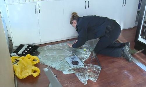 Forensic detectives check for finger prints on the broken glass. (9NEWS)