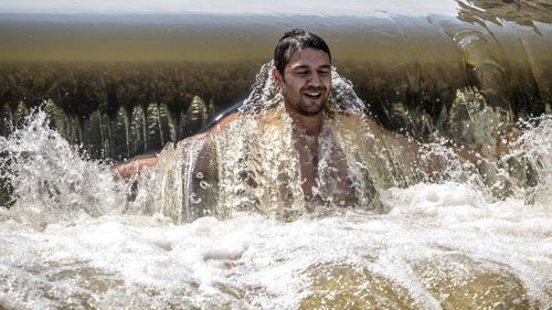 A man cools off in a weir on the Berounka river close to village of Dobrichovice, Czech Republic. (AAP)