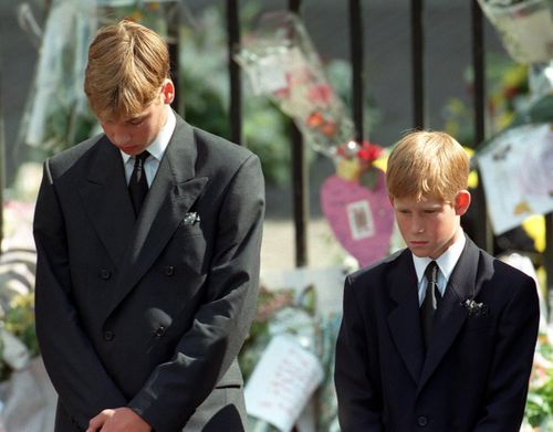 Prince William (left) and Prince Harry (right), the sons of Diana, Princess of Wales, bow their heads as their mother's coffin is taken out of Westminster Abbey following her funeral service. 6/9/1997
