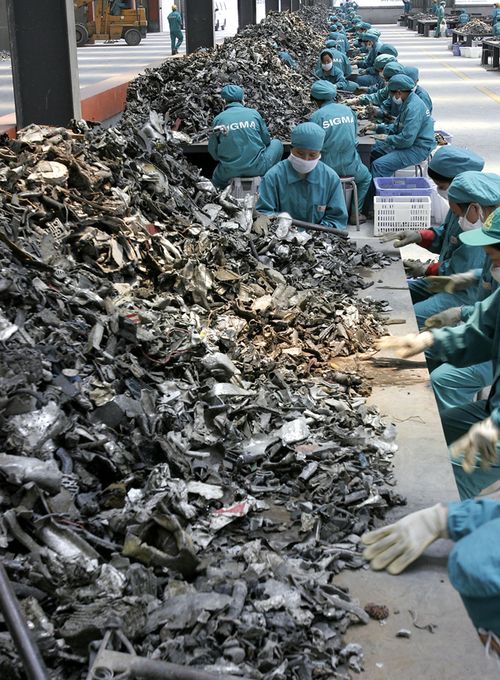 Chinese workers sellect car part scrap to collect aluminum for recycling at a smelting plant in the outskirts of Shanghai. (AAP)