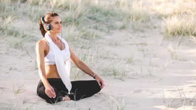 Donna Abbate meditates on beach in activewear