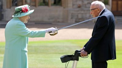 Queen Elizabeth II awards Captain Sir Thomas Moore with the insignia of Knight Bachelor at Windsor Castle on July 17, 2020 in Windsor, England.