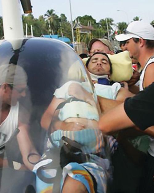 Darren being put on the tiny helicopter which his friends needed to fill with petrol from their boat. Picture: Supplied