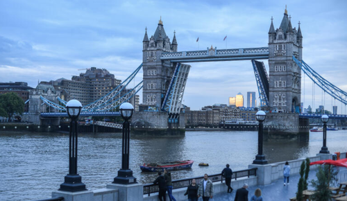 Tower Bridge is seen stuck in the raised position as people walk along the south bank on August 9, 2021 in London, England. Tower Bridge, London's 127-year-old iconic landmark, has become stuck open after a technical failure, causing major traffic issues in the capital.