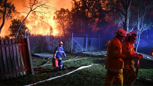 Firefighters fight flames close to homes in Corryton Court, Wattle Grove. (AAP)