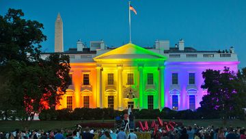 People gather in Washington&#x27;s Lafayette Park to see the White House illuminated with rainbow colours