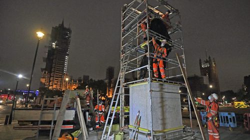 Scaffolders erect boarding around the statue of Sir Winston Churchill at Parliament Square, in London, Thursday, June 11, 2020, following Black Lives Matter protests that took place across the U.K. over the weekend