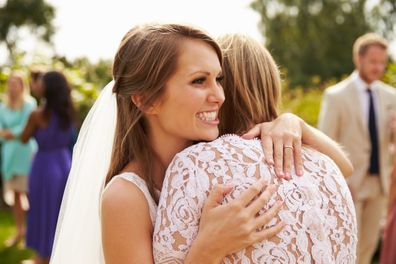 Bride hugging guest on wedding day