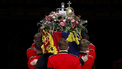 Pall bearers carry the coffin of Queen Elizabeth II with the Imperial State Crown resting on top into St. George's Chapel, in Windsor, England, Monday, Sept.  19, 2022, for the committal service for Queen Elizabeth II.  (Jeff J Mitchell/Pool Photo via AP)
