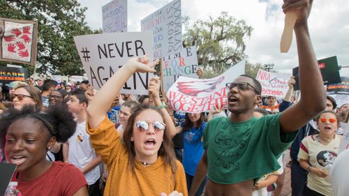 Therese Gachnauer and Kwane Gatlin join fellow students protesting gun violence. (AAP)