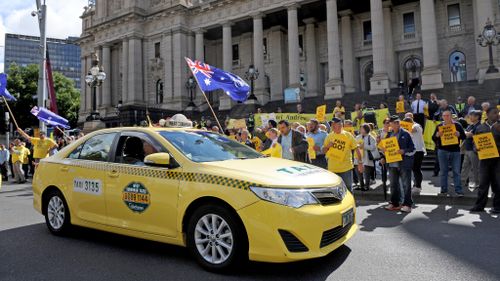 Yellow cabs and protesters in yellow t-shirts lined Spring Street. (AAP)