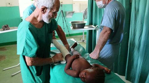 Dr Ken Elliot treats a child in Burkina Faso. (Image: GBS Institute)