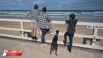 Artie the dog with his adopted family at the beach.