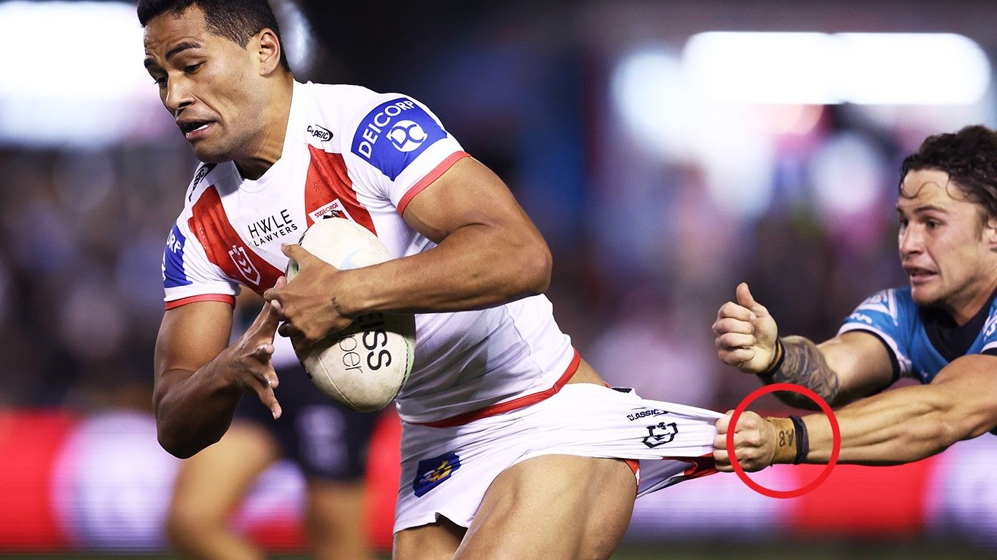 Nicho Hynes, with &quot;AB&quot; on his wristband, tries to tackle Mathew Feagai.