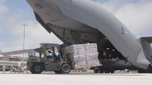 Des palettes de fournitures sont déchargées à l'aéroport international de Tonga. 