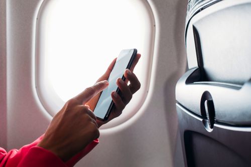 Woman using phone on plane