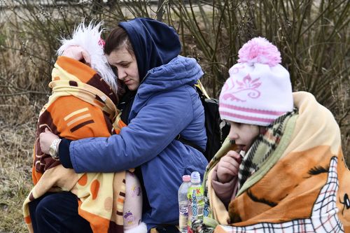 A mother hugs her daughter at a checkpoint run by local volunteers after arriving from Ukraine, crossing the border in Beregsurany, Hungary, Saturday, Feb 26, 2022. Hungary has extended legal protection to those fleeing the Russian invasion. (AP Photo/Anna Szilagyi)