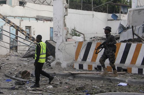 A Somali soldier walks near a destroyed building after a car bomb was detonated in Mogadishu. (AP)