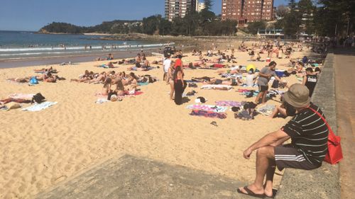 Beachgoers at Manly enjoy the unseasonal heat. (Image: 9NEWS)