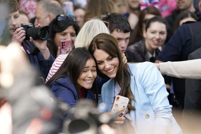 Kate, Princess of Wales poses for a selfie with a concertgoer during a walkabout meeting members of the public on the Long Walk near Windsor Castle, May 7, 2023
