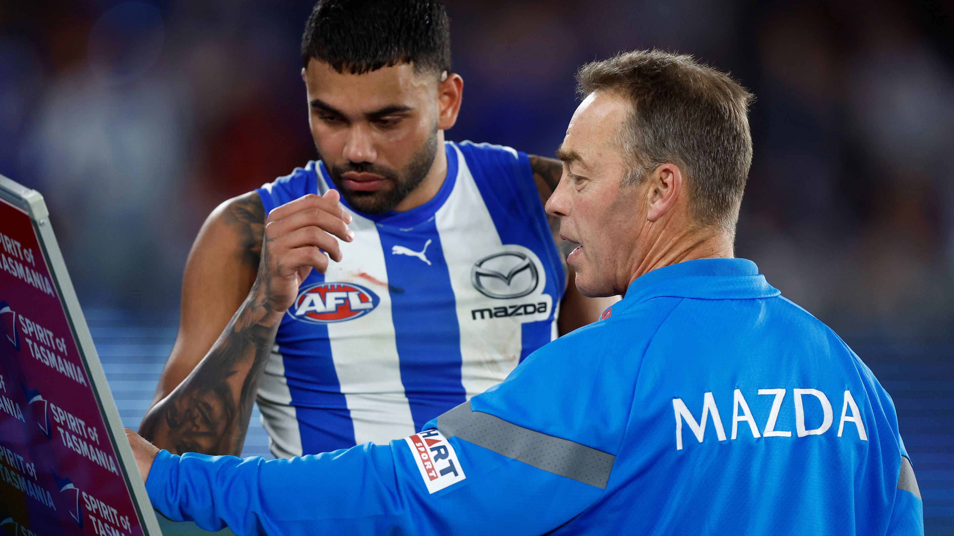 North Melbourne coach Alastair Clarkson speaks with Tarryn Thomas during the round 22 match between the Kangaroos and Essendon.