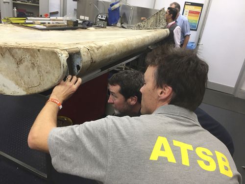 Australian Transport Safety Bureau staff examine a piece of aircraft debris at their laboratory in Canberra, in 2016.