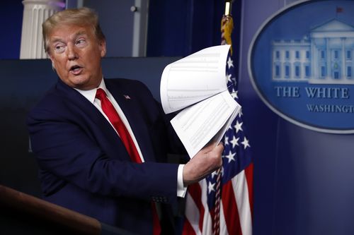 President Donald Trump holds up papers as he speaks about the coronavirus in the James Brady Press Briefing Room of the White House on April 20, 2020, in Washington.   