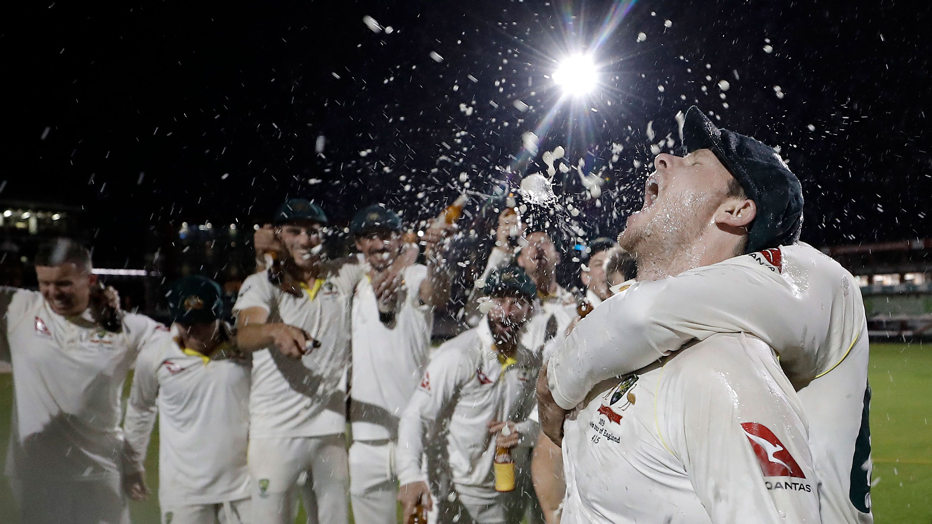 Steve Smith celebrates with his teammates while singing the team song on the pitch following victory in the fourth Test.