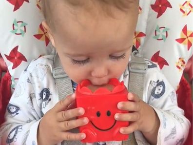 Toddler drinking tea out of a Mr. Men cup