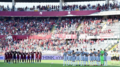 Players stand during the minute of silence in memory of the victims of the Genoa bridge collapse, prior to the Italian Serie A soccer match between Torino FC and AS Roma in Turin.