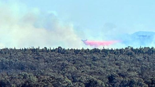 A firefighting aircraft battles a grass fire in the NSW Central West region, October 2, 2023.