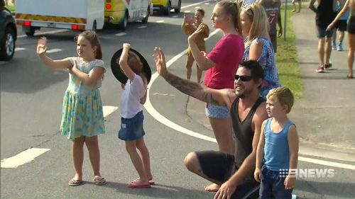 Crowds cheer the baton's arrival. (9NEWS)