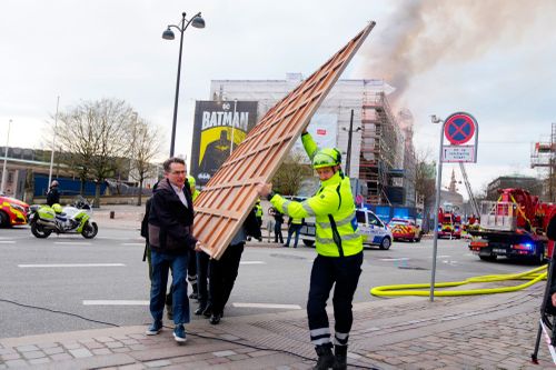 Former Danish Minister of Culture and current CEO of Danish Business, Brian Mikkelsen, left, assists with the evacuation of paintings from the Boersen burning in Copenhagen on Tuesday, April 16, 2024. 