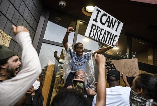 People gather at a police precinct during a protest for George Floyd in Minneapolis, on Tuesday May 26