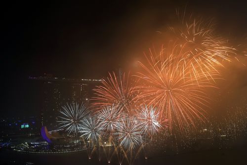 Fireworks explode above Singapore's financial district at the stroke of midnight to mark the New Year's celebrations. (AAP)