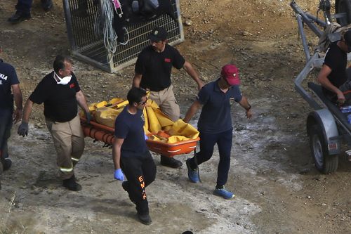 Cyprus Special Disaster Response Unit carry a suitcase after it was retrieved from a lake. (AP Photo/Petros Karadjias)