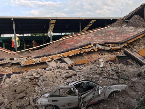 A car sits crushed, engulfed in a pile of rubble from a building felled by a 7.1 earthquake, in Jojutla, Morelos state. (AP)