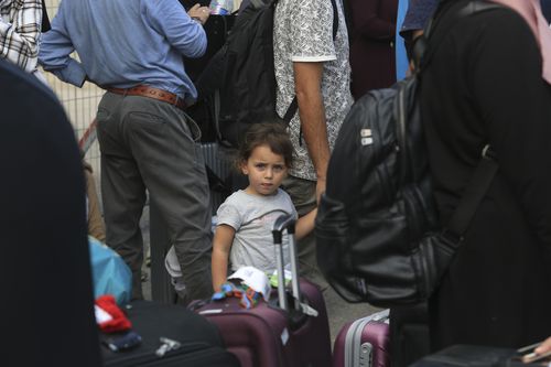 Palestinians wait at the Rafah border crossing between the Gaza Strip and Egypt Gaza Strip on Saturday, Oct. 14, 2023. 