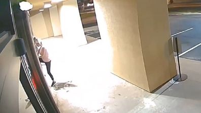 The woman is seen trying to open the door before returning with her vehicle.